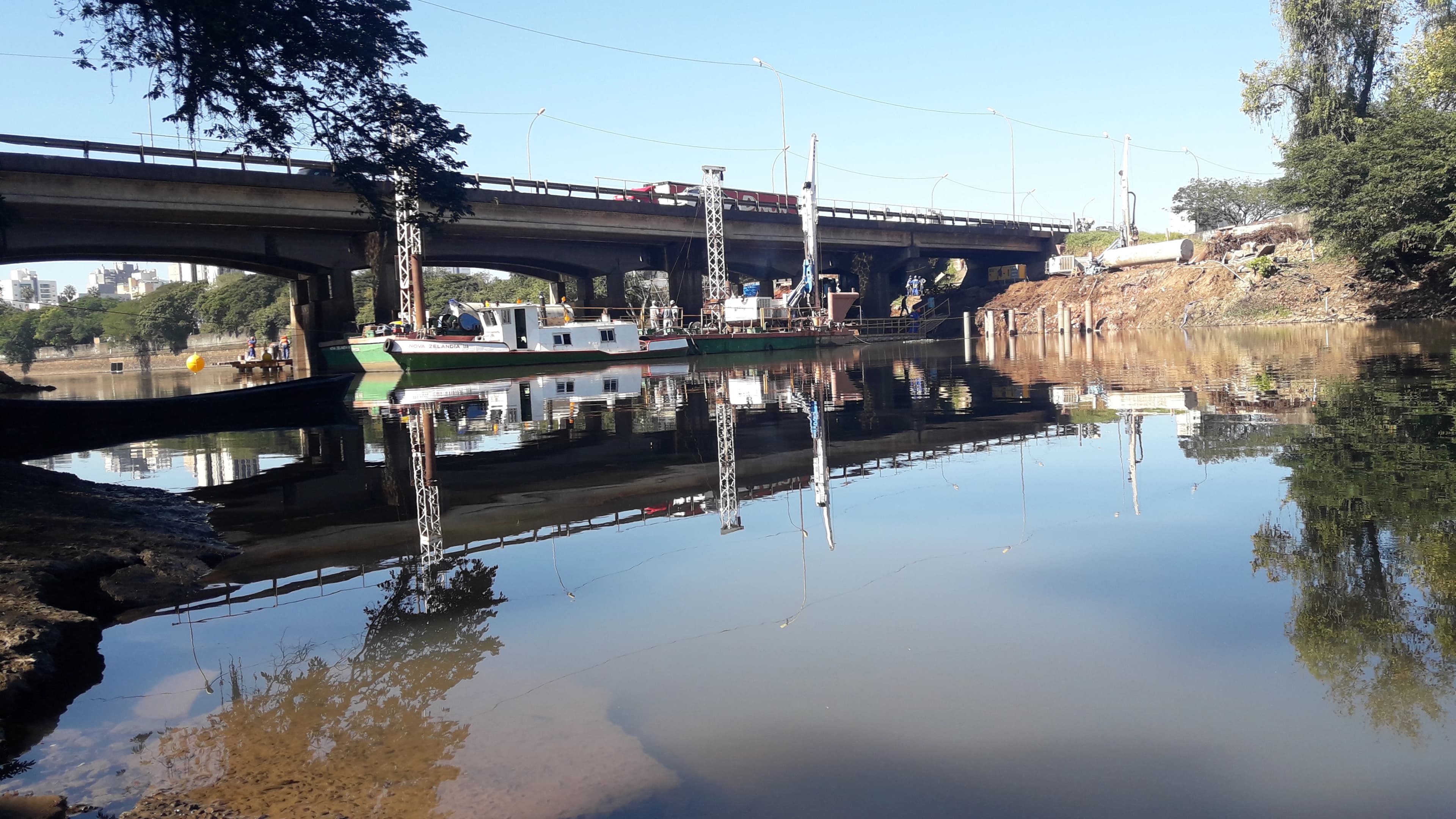 Foto de um rio com uma ponte em construção